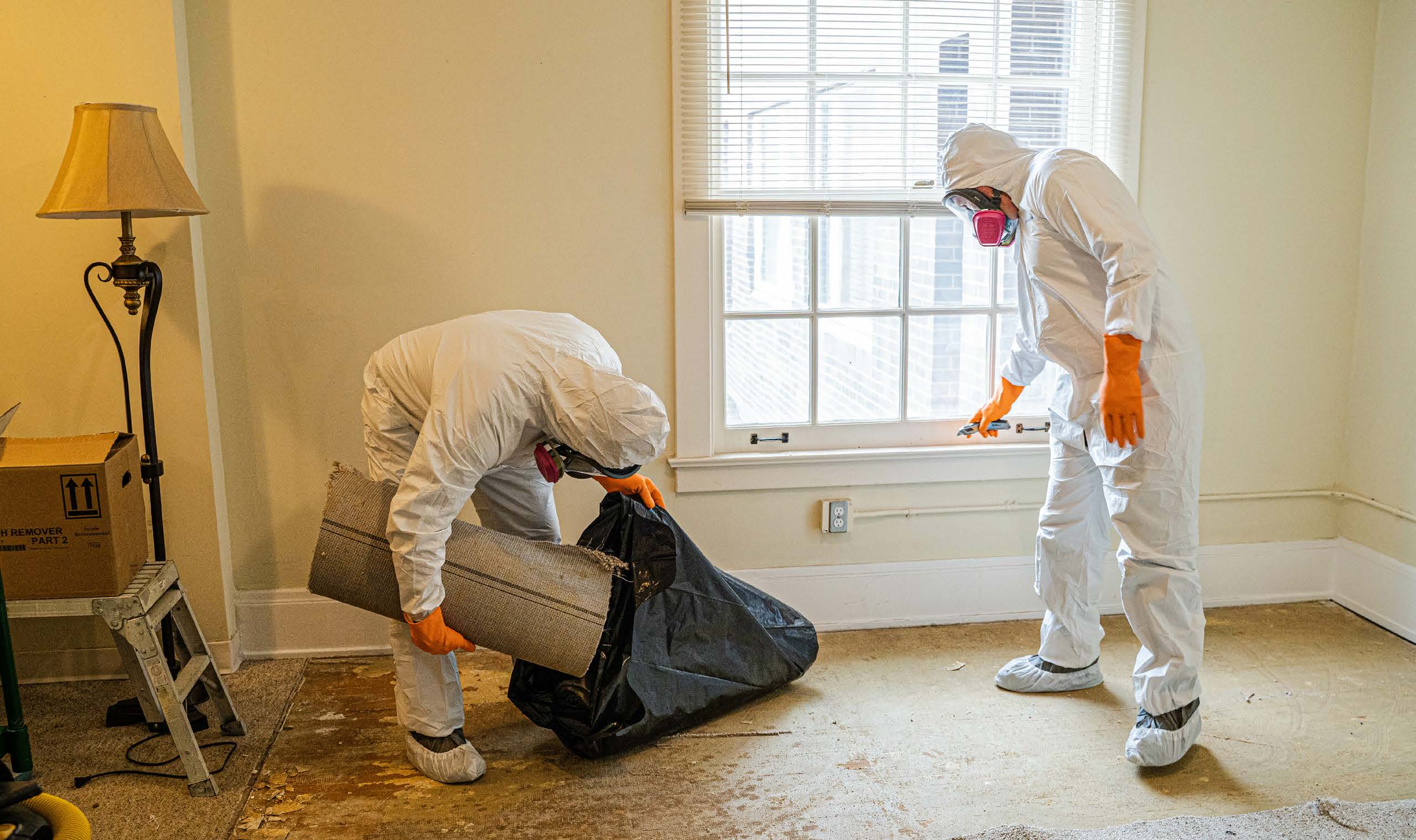 Environmental remediation team in full protective hazmat suits working inside a building