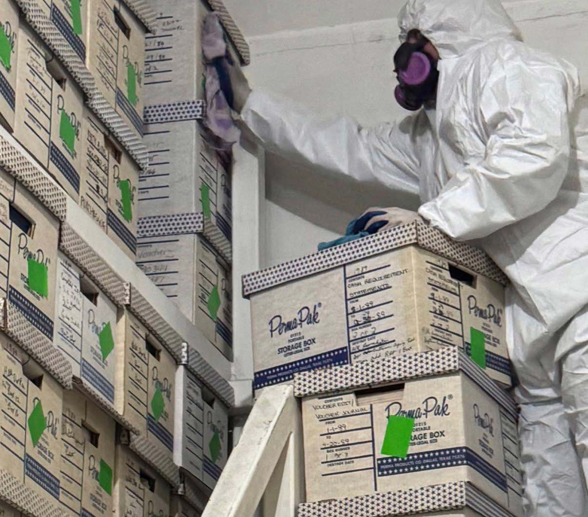 Remediation specialist inspecting stored materials in a containment area