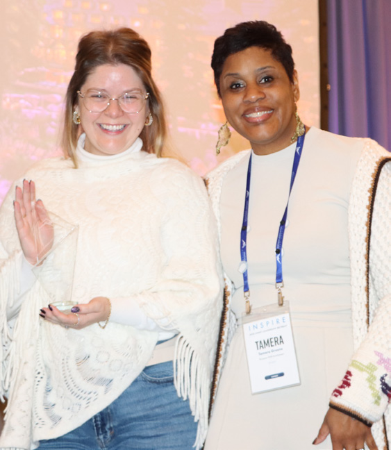 Sarah Cinderwood standing beside another woman at an indoor event