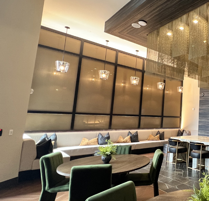 Amenity lounge with dining tables, a bar and a decorative chandelier